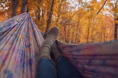 In gray socks lying in the colorful a hammock
